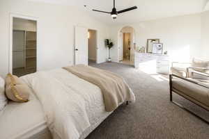 Bedroom featuring ceiling fan, carpet floors, vaulted ceiling, a walk in closet, and a closet