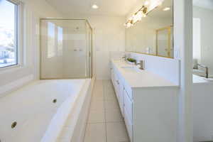 Bathroom featuring tile patterned floors, vanity, and plus walk in shower