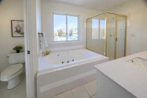 Full bathroom featuring tile patterned flooring, vanity, toilet, and plus walk in shower