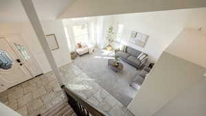 Carpeted living room featuring high vaulted ceiling