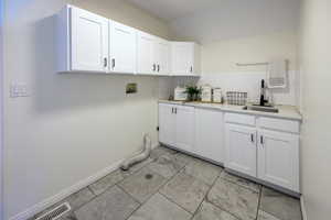 Laundry area with cabinets, sink, and hookup for a washing machine