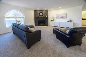 Carpeted living room with crown molding and a fireplace