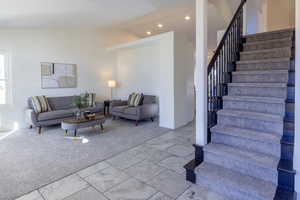 Living room featuring light carpet and high vaulted ceiling