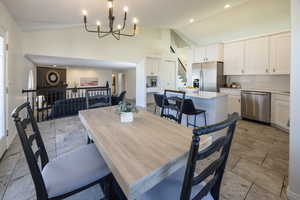 Dining area with high vaulted ceiling and a notable chandelier