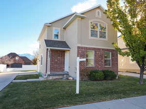 View of property featuring a front lawn