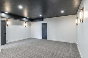 Carpeted spare room with a textured ceiling