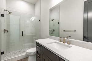 Bathroom featuring vanity, toilet, and an enclosed shower