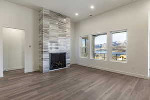 Unfurnished living room with wood-type flooring and a fireplace