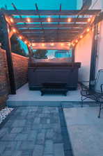 View of patio with a pergola and a hot tub