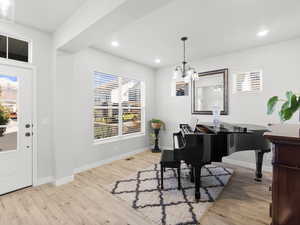 Foyer entrance  and Living room with a chandelier and light hardwood / wood-style flooring