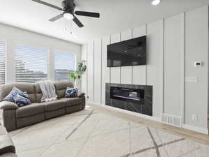 Family room featuring wood-type flooring, fireplace, a textured ceiling, and ceiling fan