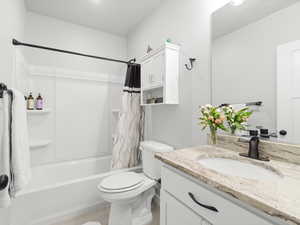 Full bathroom with tile patterned floors, vanity, toilet, and shower / tub combo