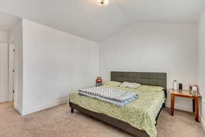 Bedroom featuring carpet floors and lofted ceiling