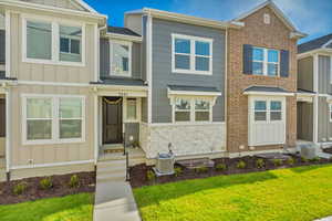 View of front of property with cooling unit and a front lawn