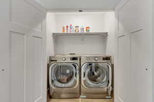 Laundry area featuring light hardwood / wood-style flooring and washer and dryer