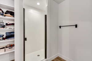 Bathroom with hardwood / wood-style floors and an enclosed shower