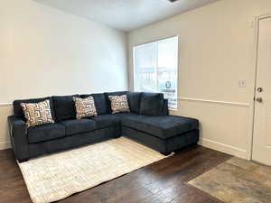 Living room featuring dark hardwood / wood-style flooring and a textured ceiling