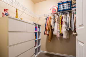 Walk in closet featuring dark colored carpet