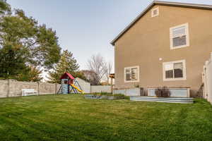 View of yard with a storage unit and a playground