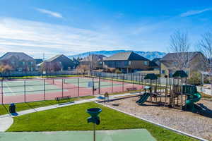 Exterior space featuring a mountain view, a yard, and tennis court