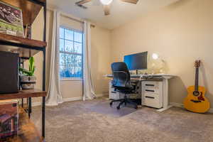 Carpeted office space featuring ceiling fan