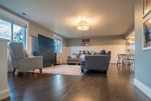 Living room with dark hardwood / wood-style floors and a textured ceiling