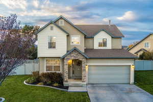 View of property with a garage and a front lawn