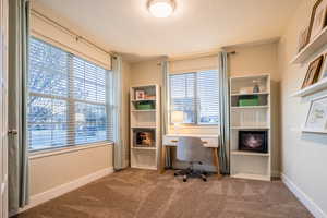 Carpeted home office featuring a textured ceiling