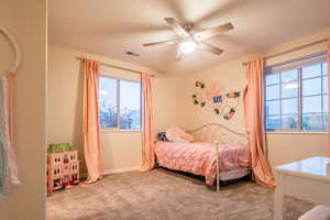 Bedroom with ceiling fan, carpet floors, and a textured ceiling