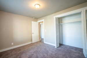 Unfurnished bedroom featuring a closet, carpet, and a textured ceiling