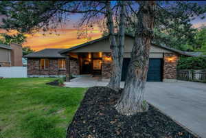 View of front facade featuring a lawn and a garage