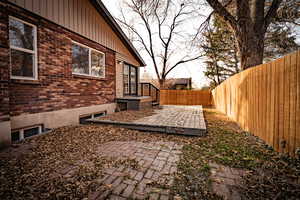 View of yard featuring a wooden deck and a patio area