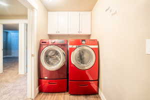 2nd laundry in basement includes washer and dryer, cabinets, lwood-type flooring