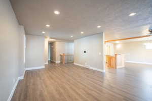 Basement with hardwood / wood-style floors, a textured ceiling, and ceiling fan