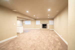 Open concept living room featuring  a fireplace and kitchen area.