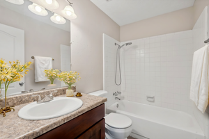 Full bathroom with vanity, toilet, and tiled shower / bath combo