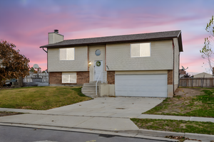 Bi-level home featuring a garage and a yard