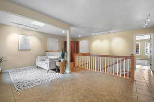 Sitting room featuring a skylight, light tile patterned floors, and track lighting