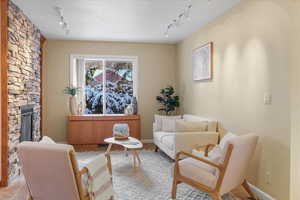 Sitting room featuring a fireplace, rail lighting, and light tile patterned floors