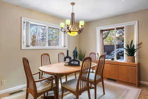 Tiled dining space featuring a chandelier