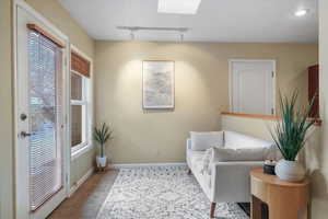 Sitting room featuring light tile patterned floors, rail lighting, and a skylight