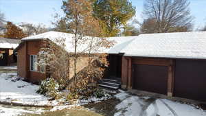 Snow covered property featuring a garage