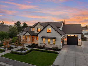 Modern inspired farmhouse featuring a garage and a lawn