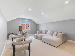 Living room featuring light colored carpet and lofted ceiling