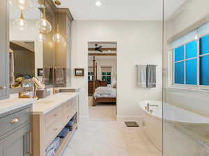 Bathroom featuring a washtub, ceiling fan, and vanity