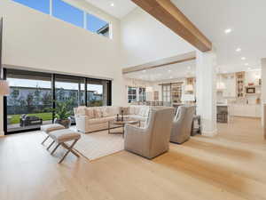 Living room featuring light hardwood / wood-style floors and a towering ceiling