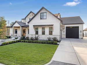 Modern farmhouse style home with covered porch, a front yard, and a garage