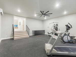 Workout area featuring an AC wall unit and ceiling fan