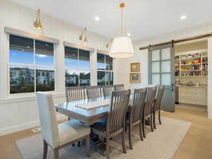 Dining room featuring light wood-type flooring and a barn door