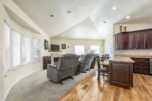 Living room with plenty of natural light, light hardwood / wood-style floors, and lofted ceiling